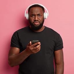 homem negro com expressão séria usando fone de ouvido